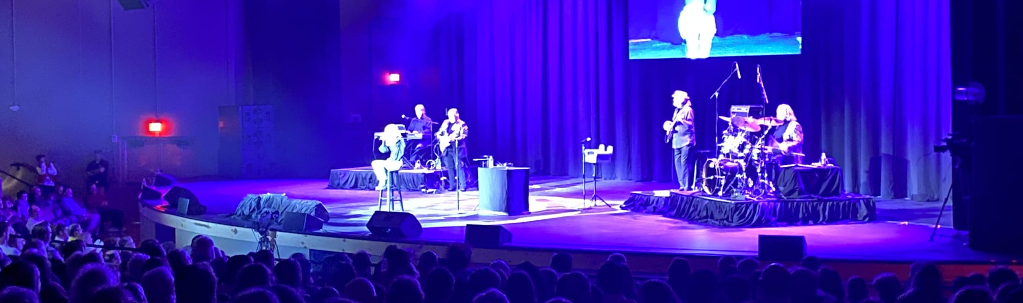 signer on stage in chair washed out by the lights Billings